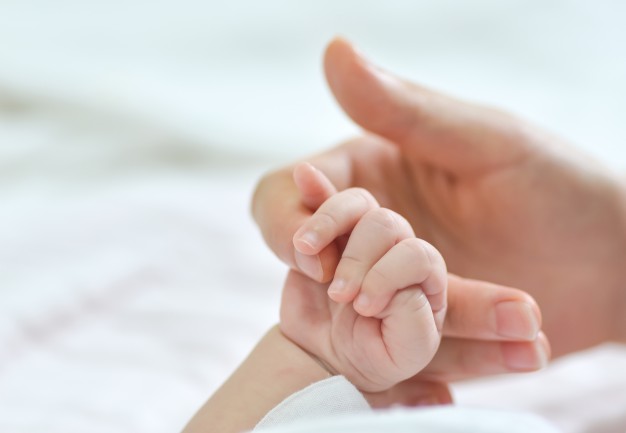 Ngay trong tháng đầu tiên sinh ra, các bé đã có phản xạ nắm tay thật chặt